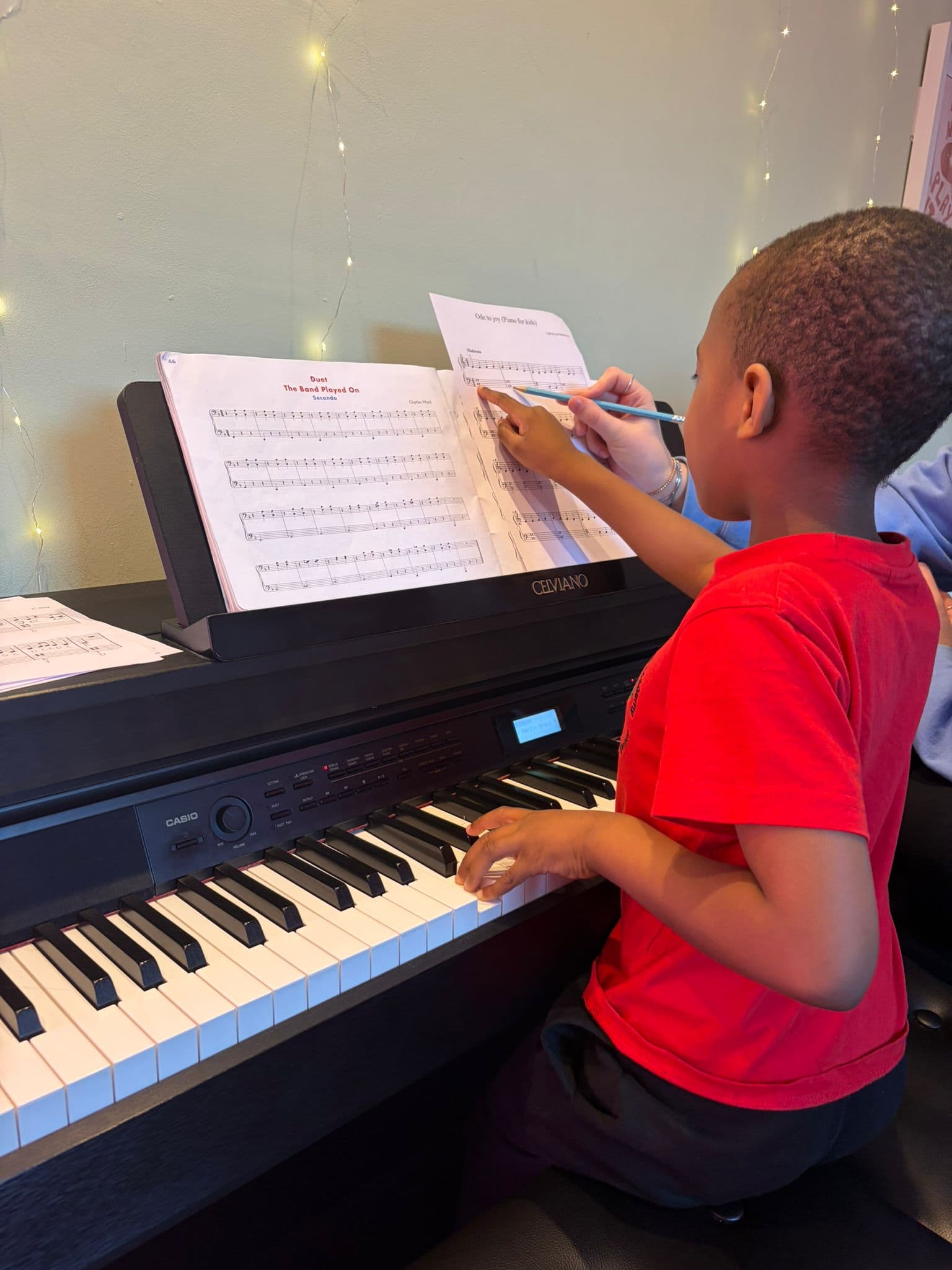 A young student learning to read music at the piano