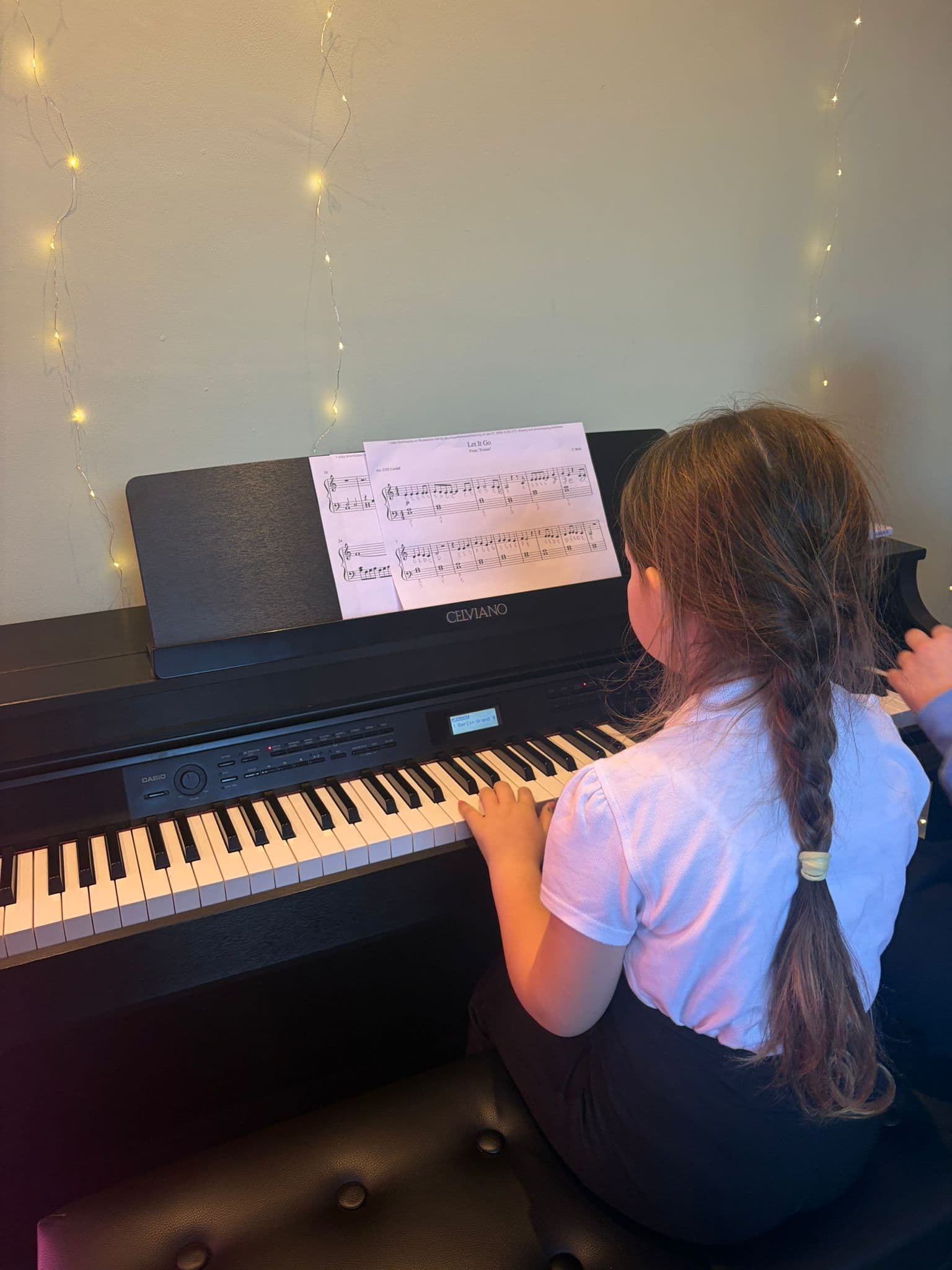 A piano student reading music while playing